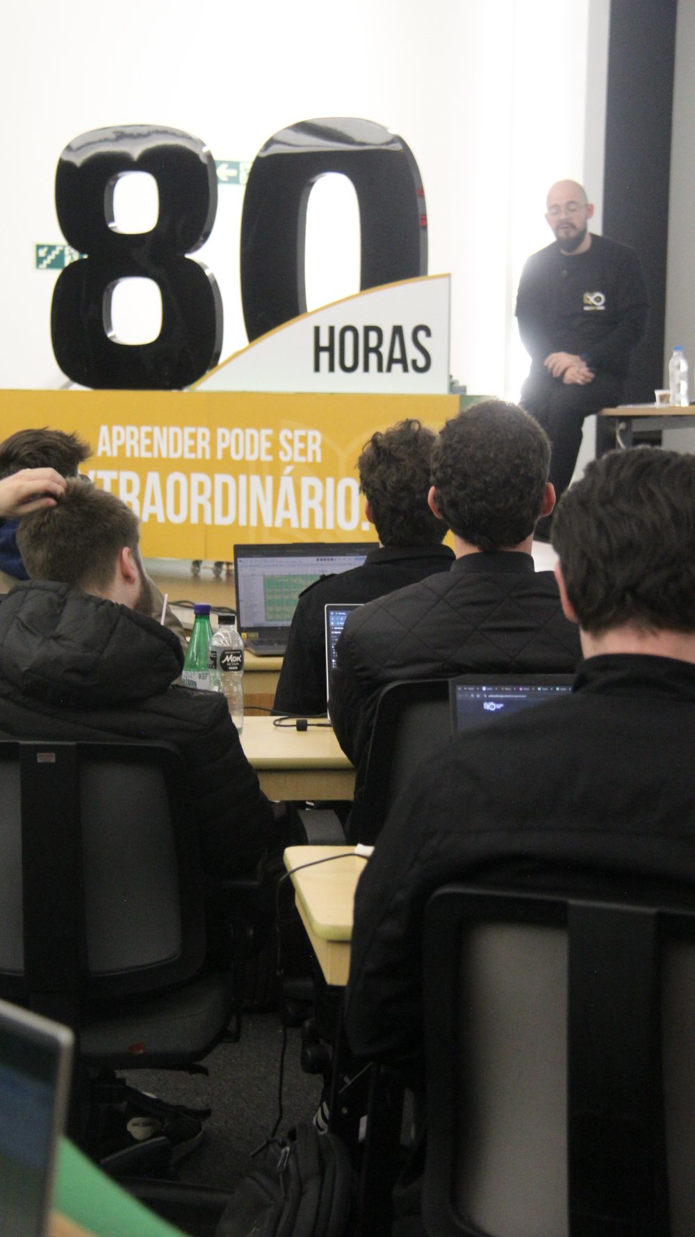 Matheus Boesing em aula, diante do painel 80 Horas